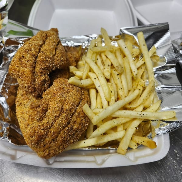 Dat Bayou Spot's fried catfish and seasoned french fries in a to-go container.