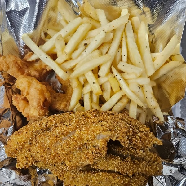 Dat Bayou Spot's fried catfish and shrimp with a side of seasoned french fries in foil.
